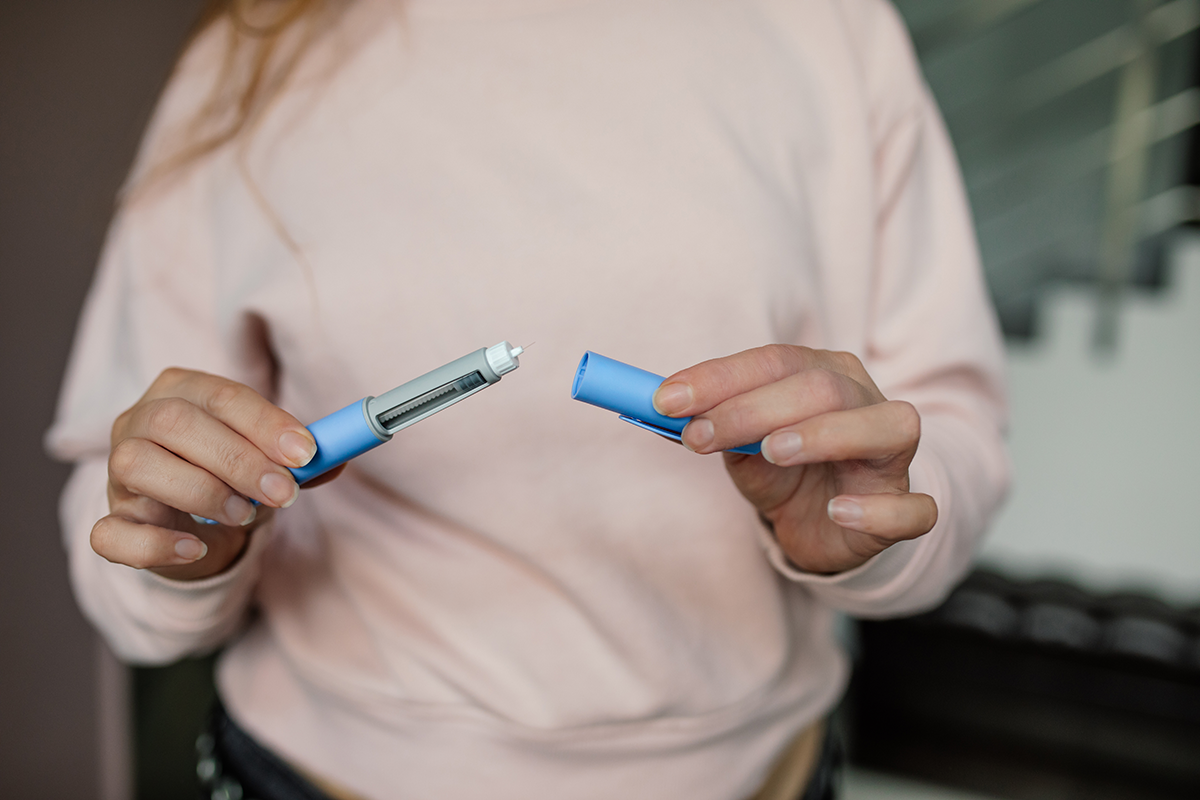 Adult preparing a GLP-1 medication injection, such as semaglutide, for weight loss or type 2 diabetes management.